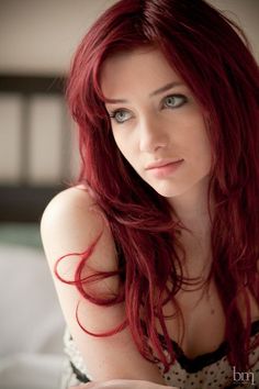 Woman with long red hair and blue eyes in a polka dot top