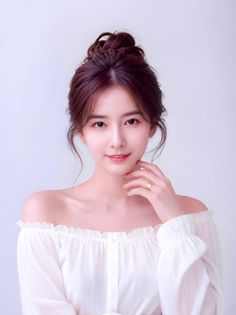 Woman with an updo hairstyle wearing an off-shoulder top and a ring