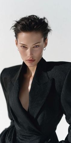 Woman with short hair wearing a black blazer with dramatic lighting