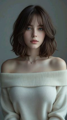 Woman with short brown hair and blue eyes wearing an off-shoulder sweater
