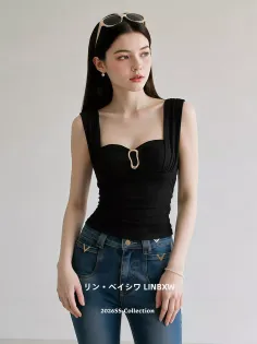 Woman in a black top and blue jeans with sunglasses on her head