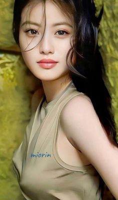 Woman with long dark hair wearing a sleeveless top with text on it
