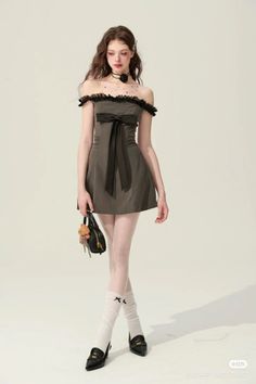 Woman in an off-shoulder mini dress with a black bow and white tights