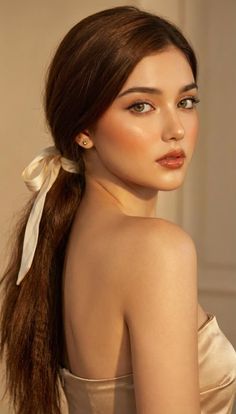 Woman with long hair tied in a ponytail with a ribbon, looking over her shoulder
