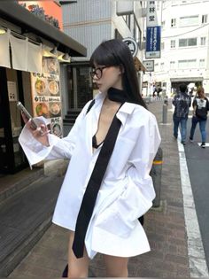 Woman in an unbuttoned white shirt and black bra on a city street