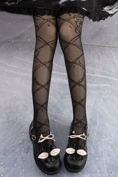 Legs wearing black tights with a thorn pattern and mary jane shoes with pink bows