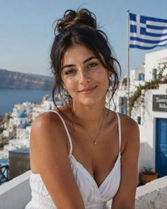 Woman in a white dress with a messy bun in a Greek village