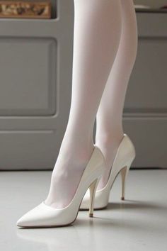 Person wearing white tights and white high heels indoors