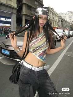 Woman in a crop top and cargo pants posing on a city street