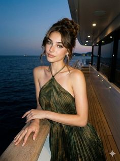 Woman in a green halter dress on a yacht at night