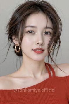 Woman with brown hair and hoop earrings wearing a red off-shoulder top