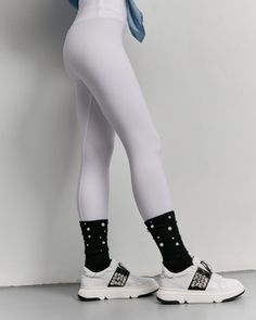 Person wearing white leggings, black pearl-embellished socks, and white sneakers