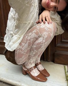 Woman in a white dress and lace tights winking at the camera