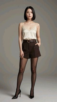Woman with short black hair wearing a camisole, shorts, and polka dot tights