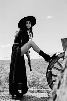 Woman in a wide brim hat and long skirt posing outdoors