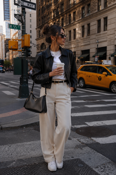 Woman in a leather jacket and wide leg pants on a city street