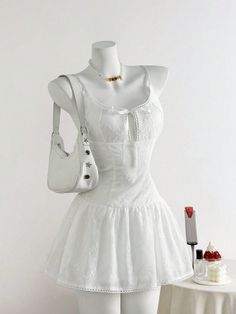 White dress on a mannequin with a handbag and necklace