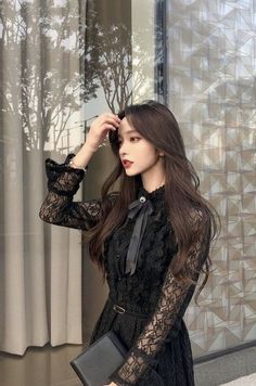 Woman in a black lace dress with a bow collar, outdoors