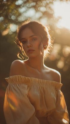 Woman in an off-shoulder top with curly hair in golden hour sunlight