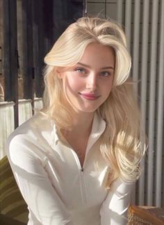 Blonde woman in a white top with soft lighting indoors