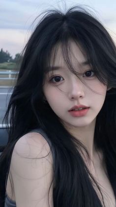 Woman with long black hair in an outdoor portrait with soft lighting