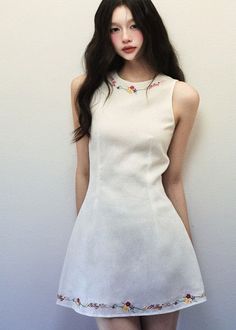 Woman in a white dress with floral embroidery and blush makeup