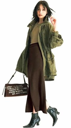 Woman in a khaki jacket and long skirt with a shoulder bag