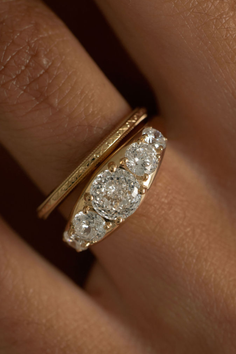 Close up of a gold ring with multiple diamonds on a finger