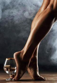 Bare legs and feet with a wine glass filled with cork stoppers