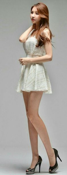Woman in a white dress and high heels posing in a studio