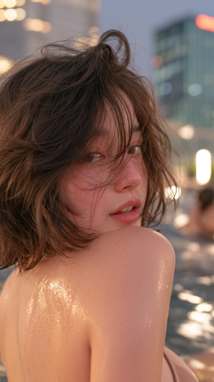 Woman with wet short brown hair and exposed wet skin looking over her shoulder