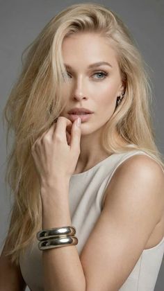Woman with blonde hair and blue eyes wearing a sleeveless top and silver jewelry