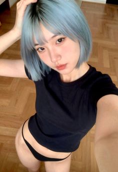 Woman with blue short hair and black t-shirt and underwear posing indoors