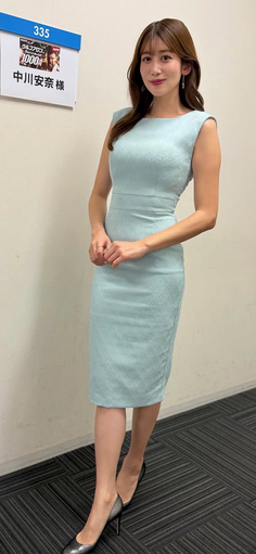 Woman in a light blue dress and high heels standing indoors