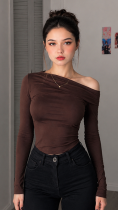 Woman in a brown off-shoulder top and black jeans with an updo hairstyle