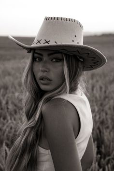 Woman in a cowboy hat with long blonde hair in a field