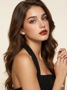 Woman with long wavy hair and red lipstick wearing a black top