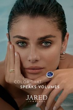 Woman with wet hair and green eyes wearing a sapphire ring and earrings