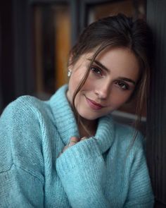 Woman in a blue sweater with soft lighting indoors