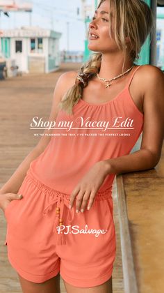 Woman with braided blonde hair wearing a coral romper on a pier