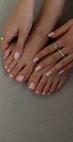 Hands and feet with light pink manicure and pedicure, adorned with rings