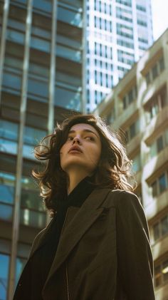 Woman with curly hair and freckles looking up in a city setting