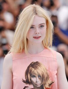 Young woman with blonde hair and freckles wearing a pink top
