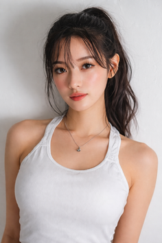 Woman in a white tank top with a ponytail and necklace, looking at the camera