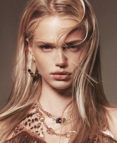 Blonde woman with long hair and gold jewelry wearing leopard print top