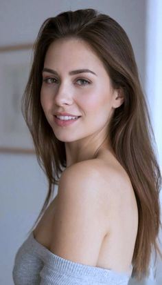 Woman with long brown hair and exposed shoulders smiling at the camera