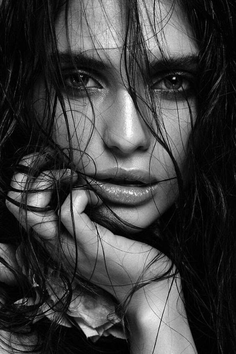 Close up portrait of a woman with wet, dark hair covering her face