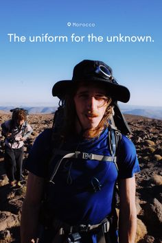 Two people hiking in rocky terrain under a clear blue sky