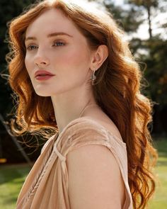 Woman with long red hair wearing a velvet dress outdoors