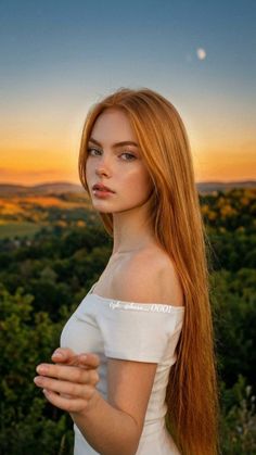 Woman with long red hair in a white off-shoulder dress at sunset